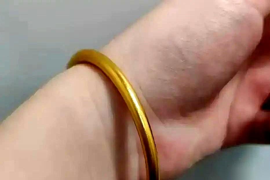 金店老师傅把放大镜从眼前挪开，推了推老花镜，整个柜台的射灯都打在他花白的头发上。
