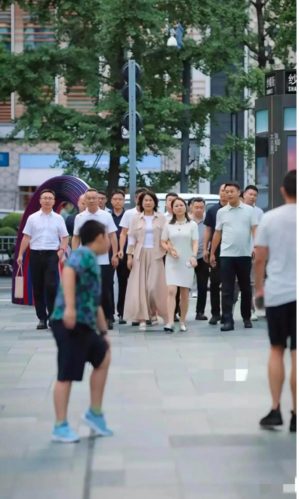 董明珠现身成都太古里，鲜衣盛装、前呼后拥地走在一众男人前面彰显霸气，与陪同人员大