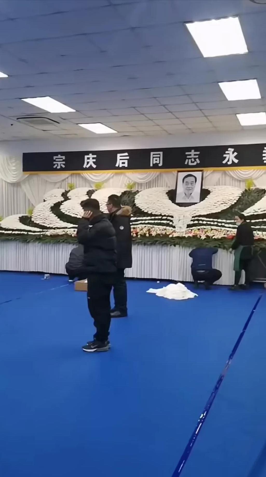 宗庆后灵堂布置现场曝光！遗像周围被白色“心”形花环包围，上配一条黑底白字的挽联，