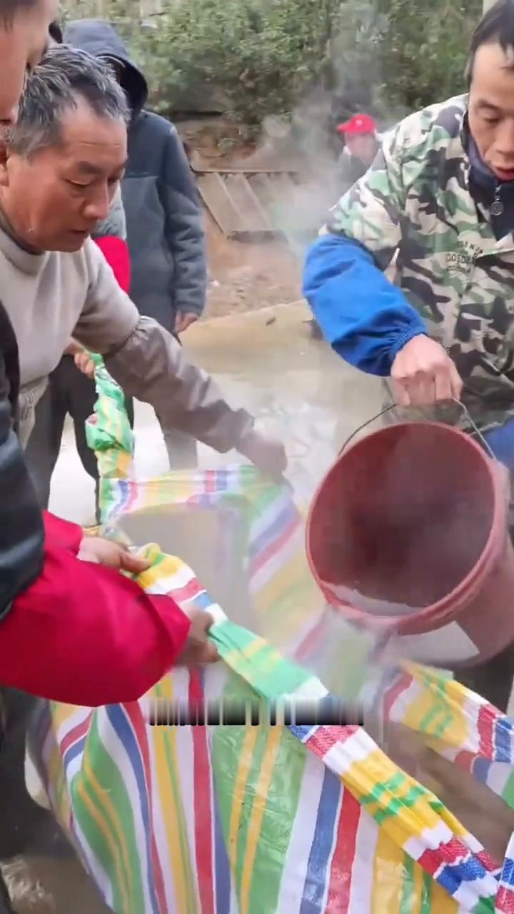 大家注意看，几位村民合力一起晃动地上的大塑料袋，很多人不知道他们这到底是在干什么