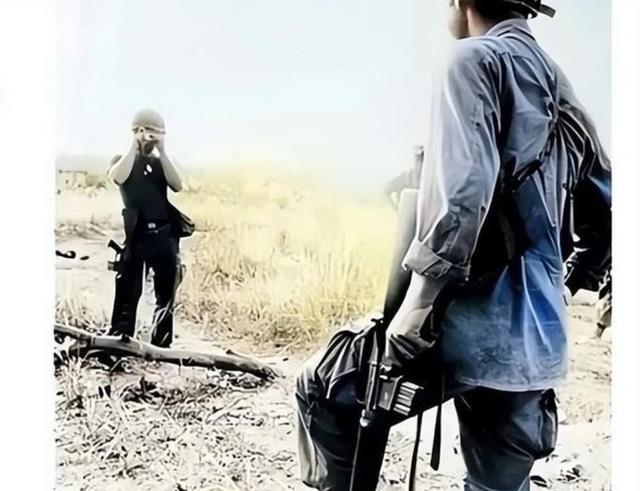 1972年，战场上躺着一个越南女兵的尸体，旁边的美国士兵先是扯下她的裤子，再翻起