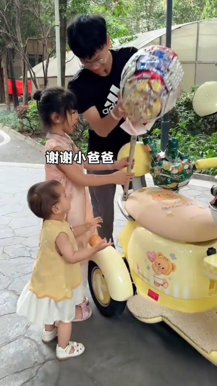 玥玥，小爸爸。谢谢小爸爸。这么大一个棒棒糖，玥玥都扛不动了，居然还给妹妹做了一个