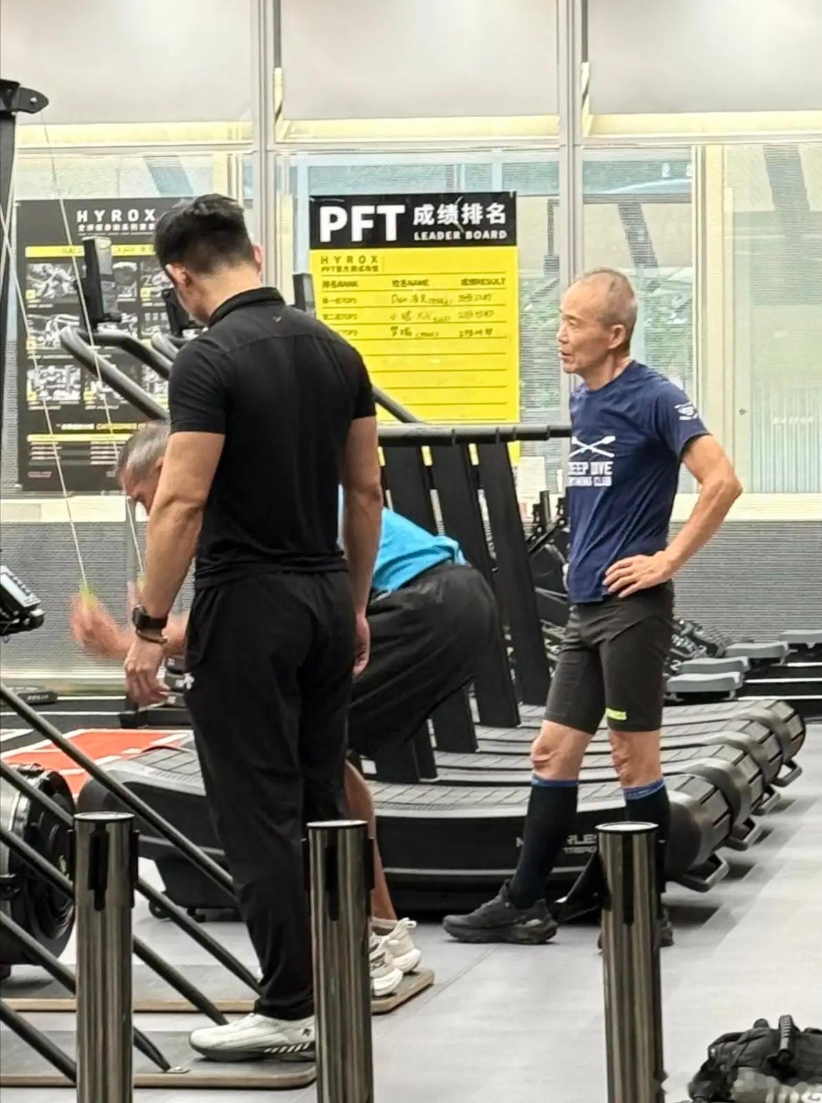 75岁王石在健身房锻炼身体被偶遇，他穿着一身运动服，在一名男教练的指导下做臂力训