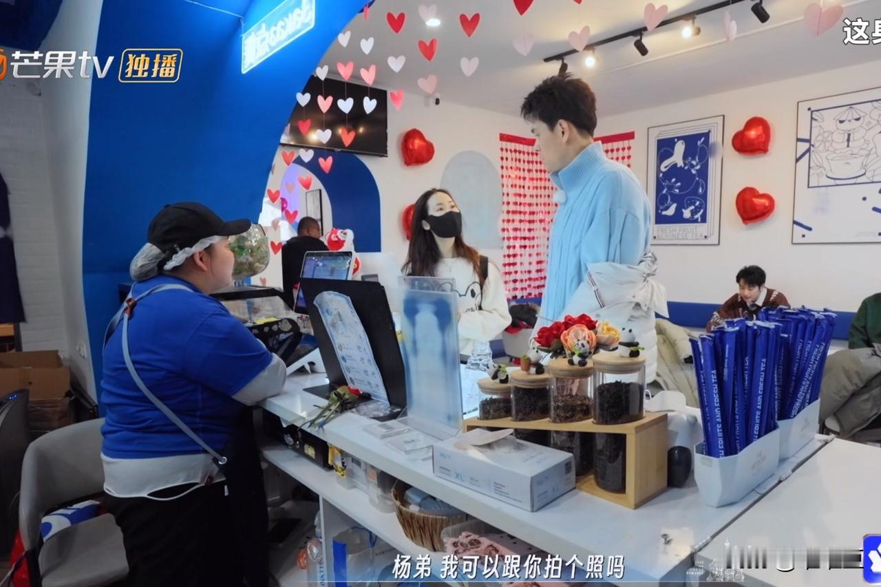 在奶茶店被认出后，女生想和孙杨合照。就在孙杨脱掉外套，露出蓝色的毛衣，正准备拍照