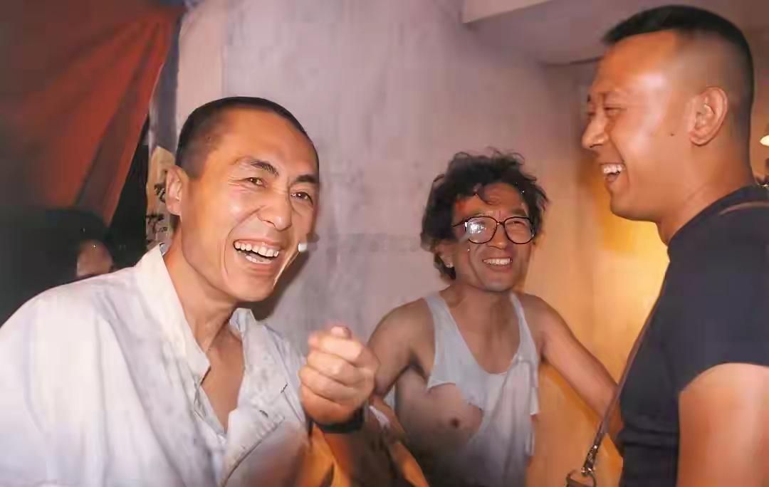 1996年，在电影《有话好好说》的拍摄现场，导演张艺谋正在给演员姜文和李保田讲戏
