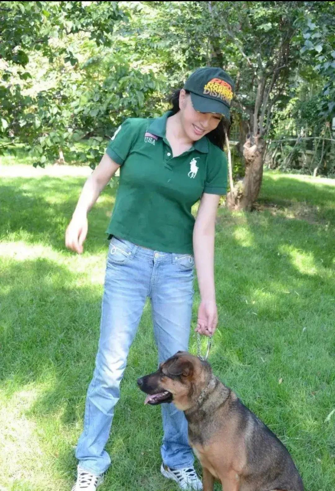 刘晓庆花园遛狗，头戴棒球帽，身穿绿色体恤衫配牛仔裤，腰上没一丝赘肉，身材曲线迷人