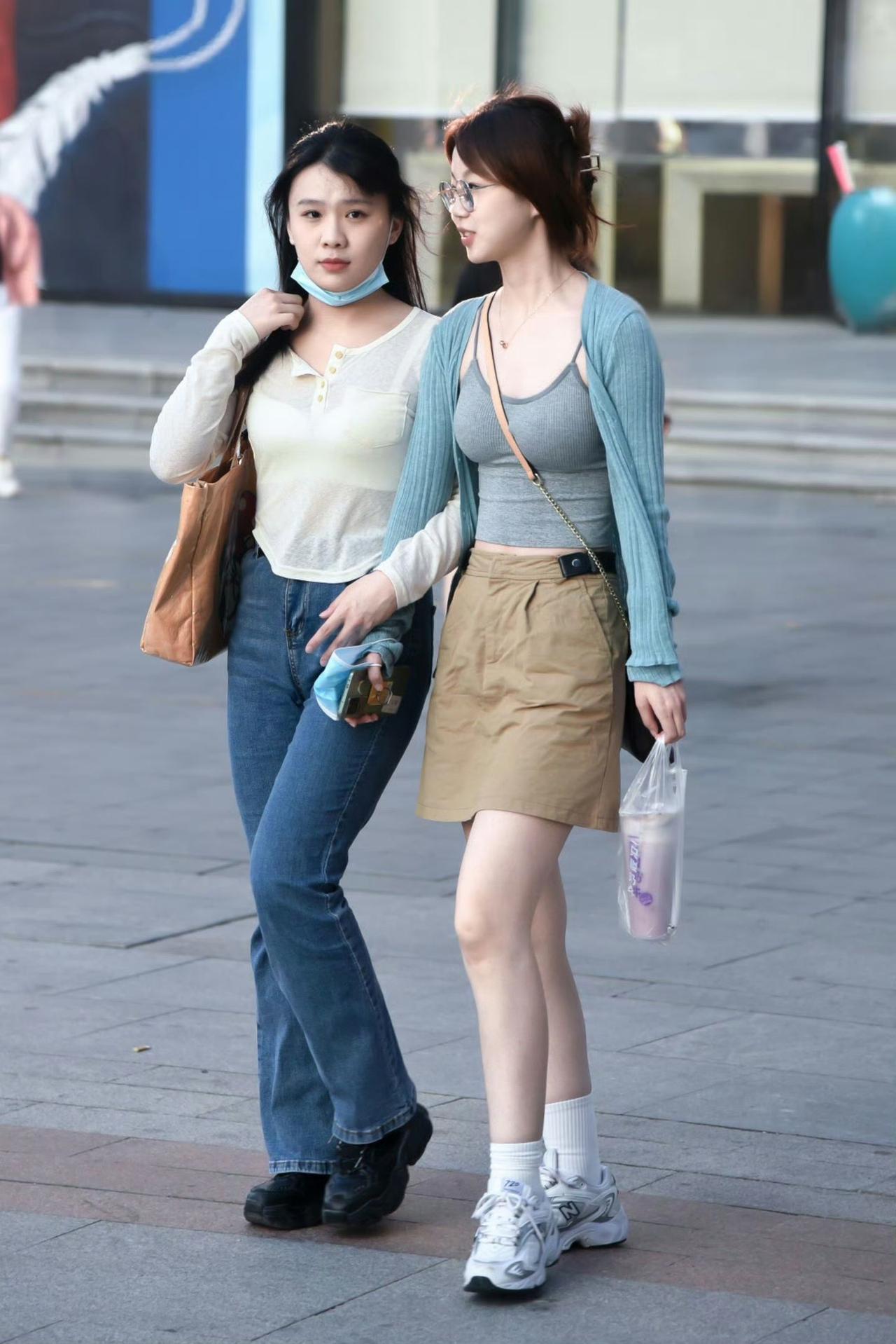 街头的夏日穿搭图鉴太养眼啦！闺蜜同行的画面里，有人偏爱清新的蓝灰系针织搭配卡其裙
