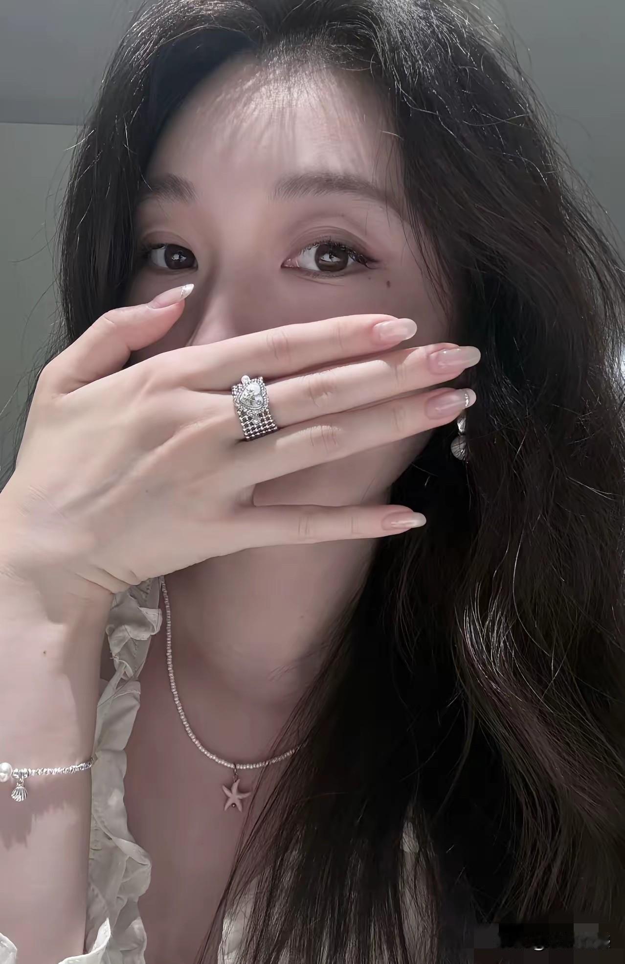 这个女子长得非常漂亮，尽管她用手遮住了面部，但是也能够感受到这个女子是一个非常漂