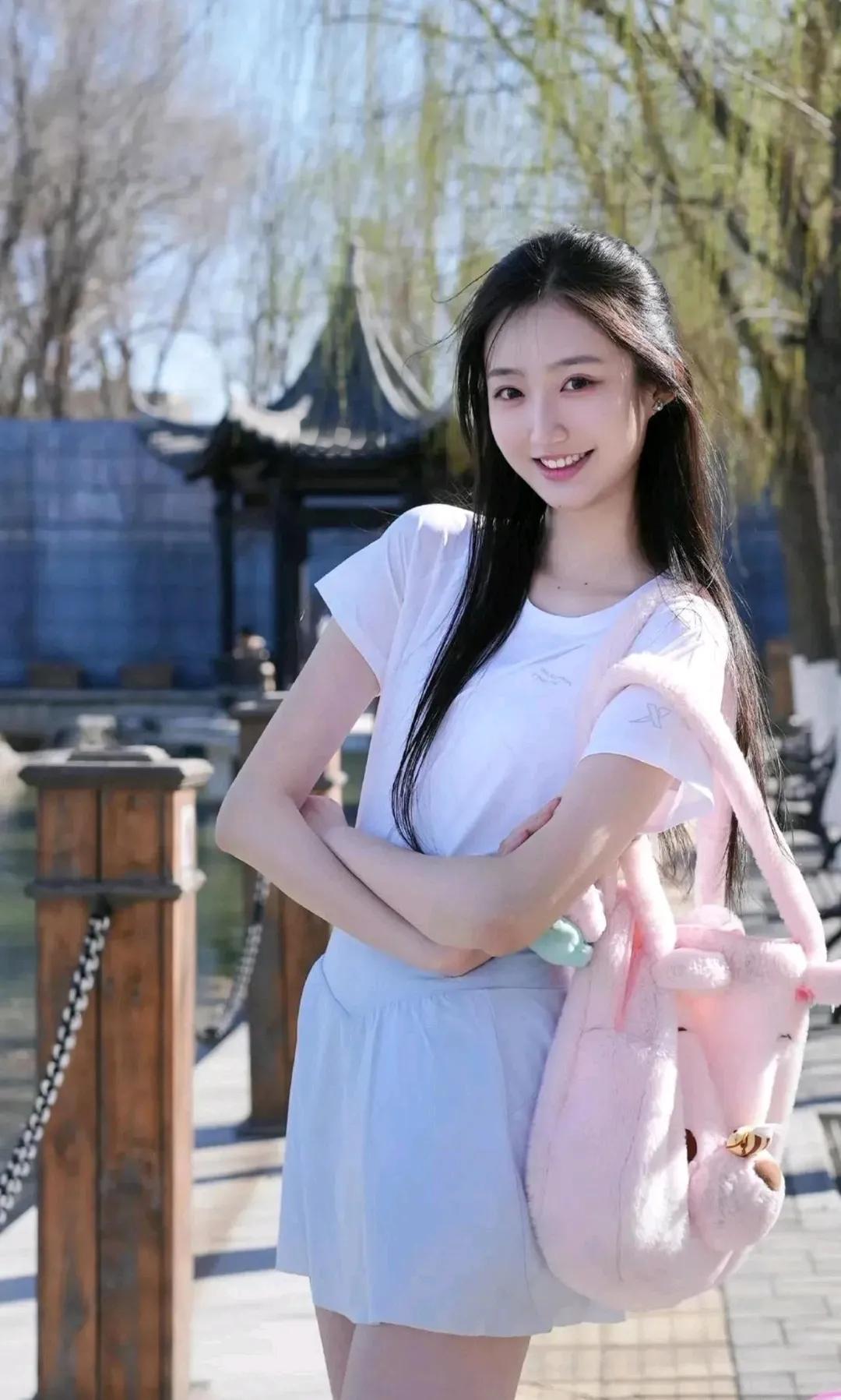 元气少女漫步在古风园林，笑容甜美，粉色小包可爱满分！🌸💕