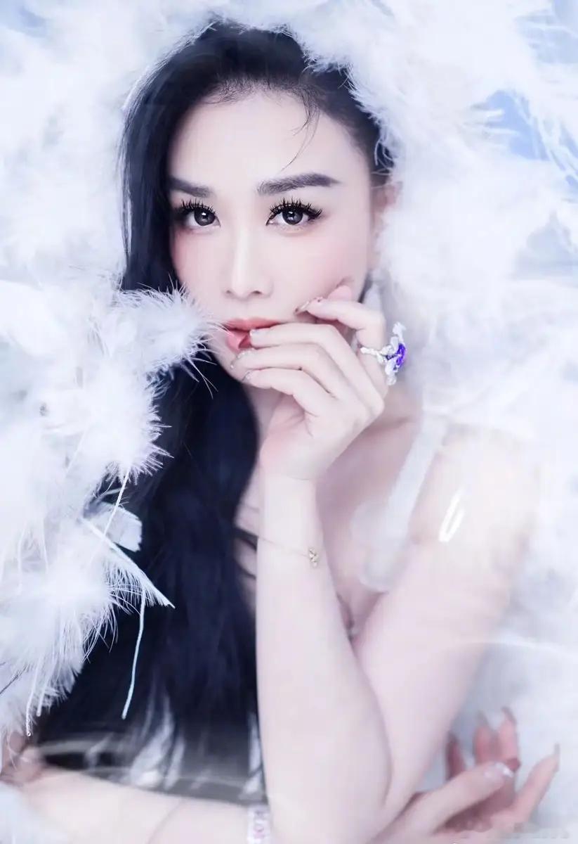 搜狐娱乐讯 24日，钟丽缇在社交平台上晒出一组美照，她身着一袭吊带羽毛裙，眼神妩