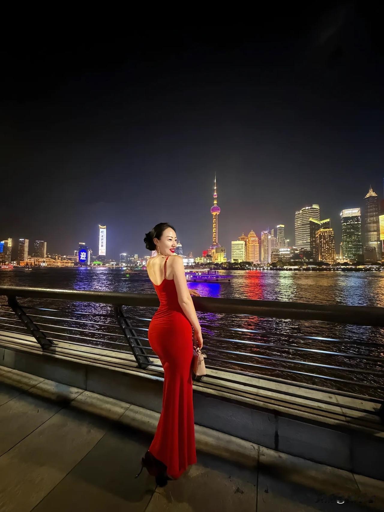 夜晚上海滩的迷人夜景，红裙美人倚栏欣赏