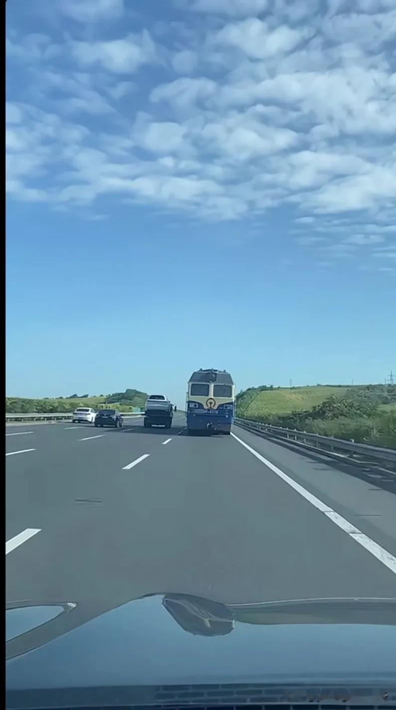 你在高速公路上见过火车吗？最近就有车主拍下了这样的一幕，前方赫然挺着一副巨大的火