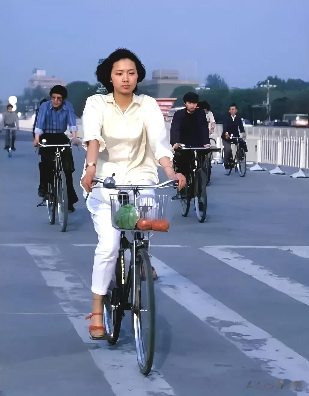 这是上世纪八十年代北京长安街，一女子骑着自行车行走在马路上，所骑自行车应该是上海