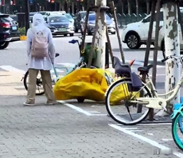 上海，现代人压力真大，看这位女子，把内心的火气发泄到无辜的自行车上面。大热天的，