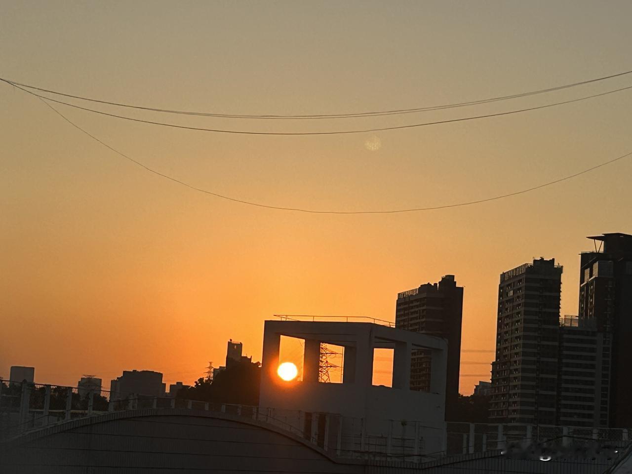 分享今天很开心的事：上楼顶收被子，遇见日落，定格在前面那栋楼的架空格里。今天是3