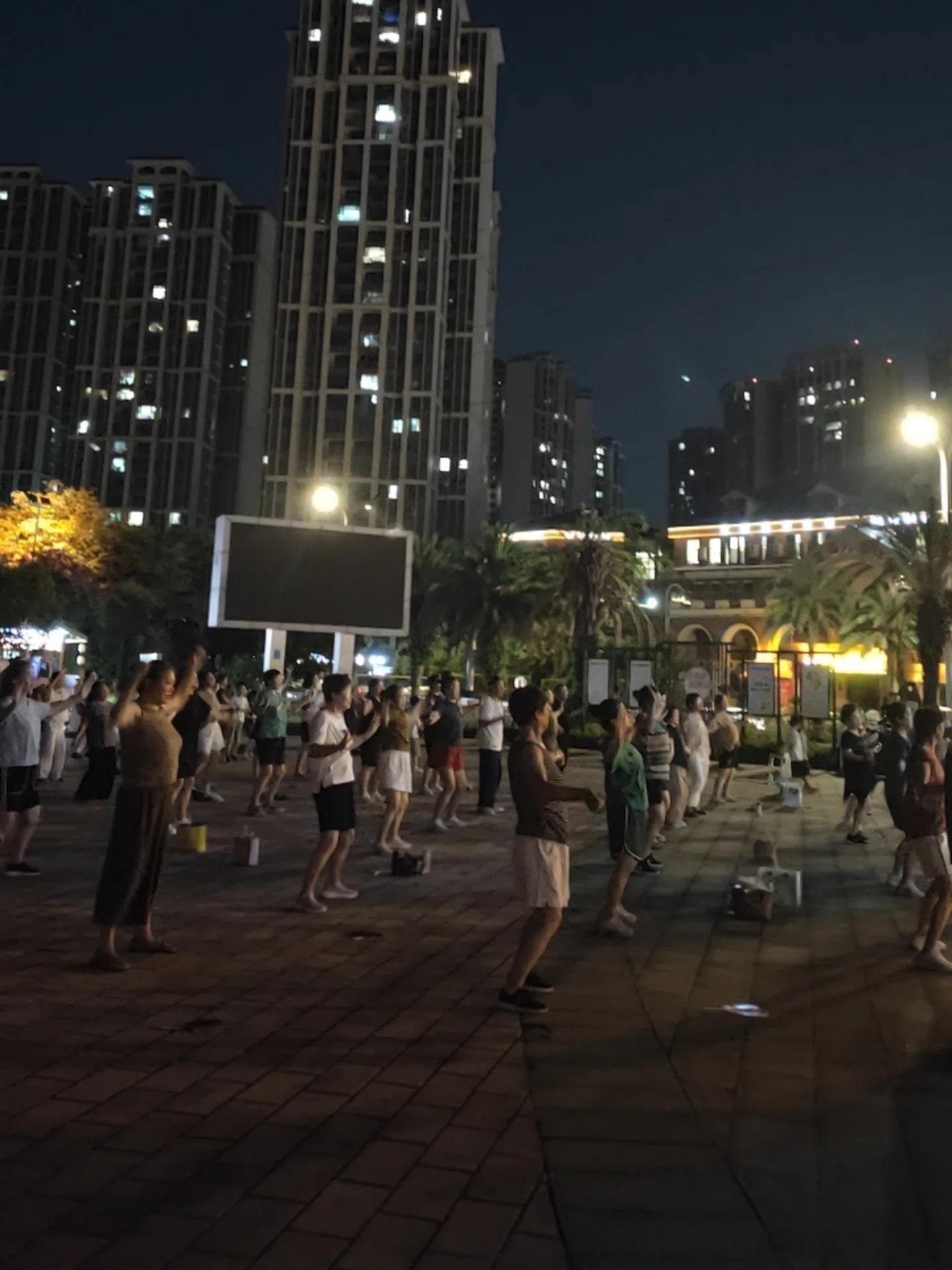 夜晚散步，撞见两种风景。湖边看灯火倒影，转头就是广场热闹的人群，这就是最真实的市