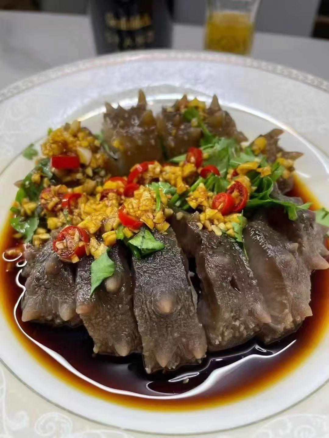 一盘QQ的即食海参，撒满葱花和辣椒。