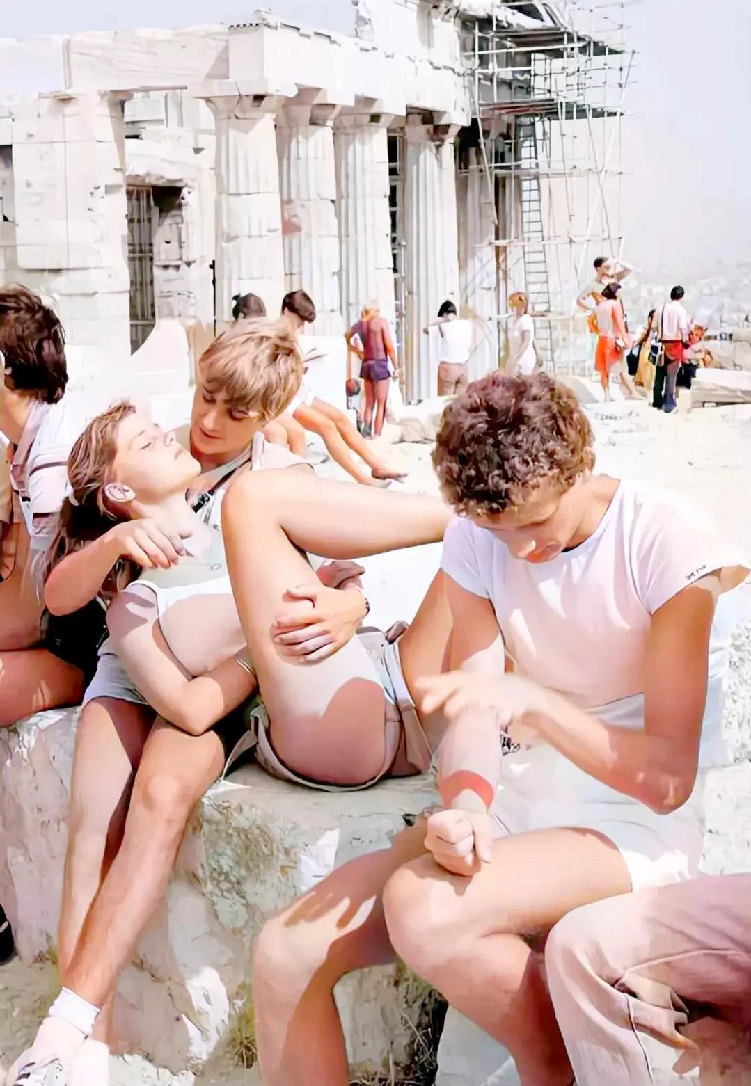 这张照片拍摄于1986年的希腊，无所事事的年轻人在雅典卫城的遗迹前聚集玩耍，镜头