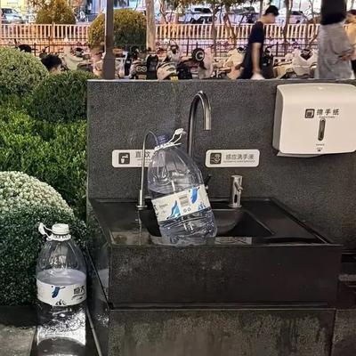 一男子提着个大塑料水桶，跑到胖东来门口接水回家煮饭，店员看到了过去提醒反而被投诉