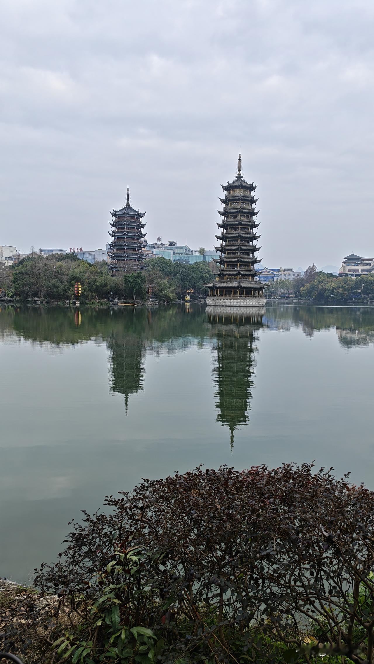 七层飞檐接云霓。
天光云影共徘徊，
塔影沉波镜未移。
青瓦朱栏凝古韵，
碧湖绿树