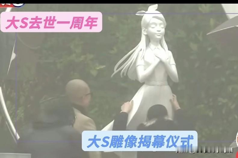 这是具俊晔为大S亲手做的雕像，长头发戴着蝴蝶结，双手交叠放在胸口，穿着长款连衣裙