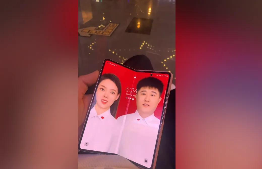 横向折叠屏手机的新玩法？！
有个网友把荣耀折叠屏手机的壁纸换成了类似于结婚证件照