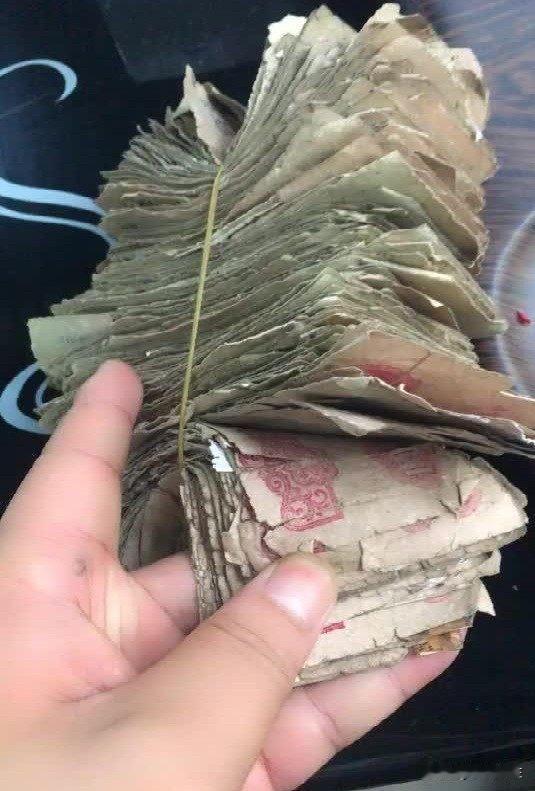 老宅拆迁时，木工师傅在房梁夹层里发现了个生锈的铁皮盒。打开一看，泛黄的纸币静静躺