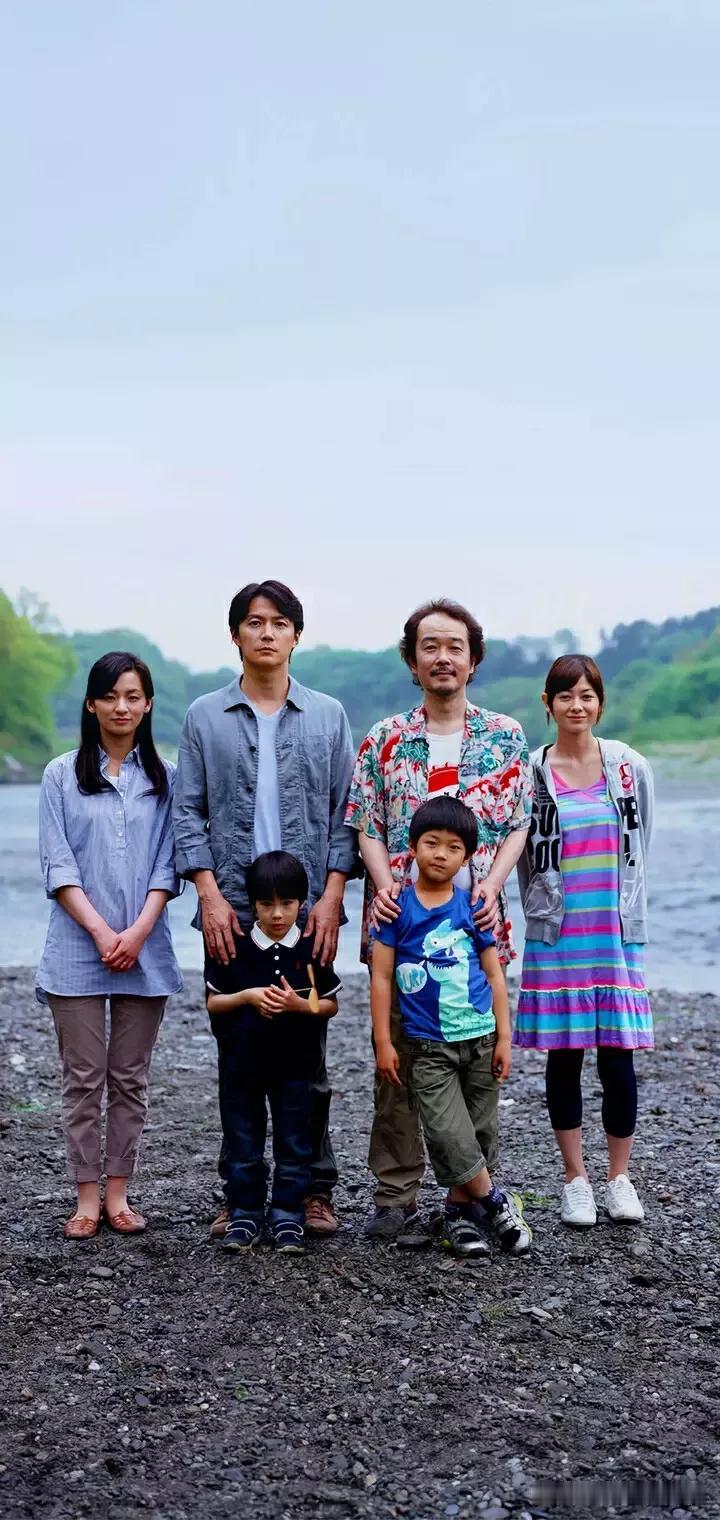 那天秋高气爽，一家人来到小河边。阳光洒在水面上，波光粼粼。
爸爸、妈妈和孩子，脸