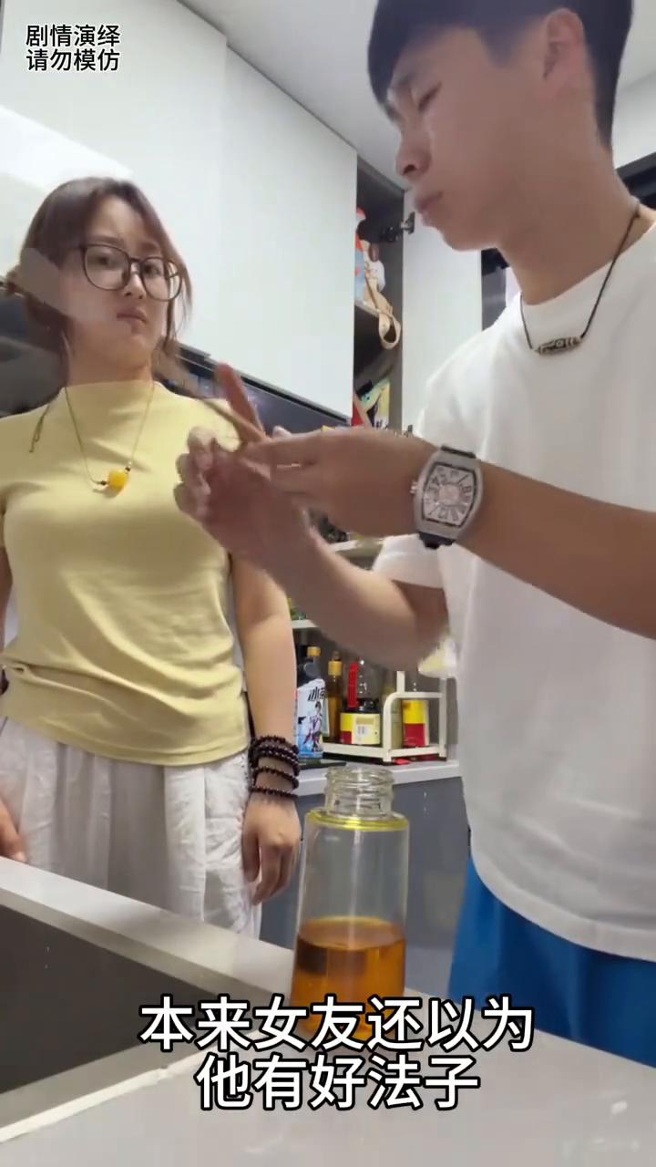 男友让女友听他的往小瓶子里倒食用油，谁知结局尴尬了。
女子拿着大油桶往瓶子里倒，
