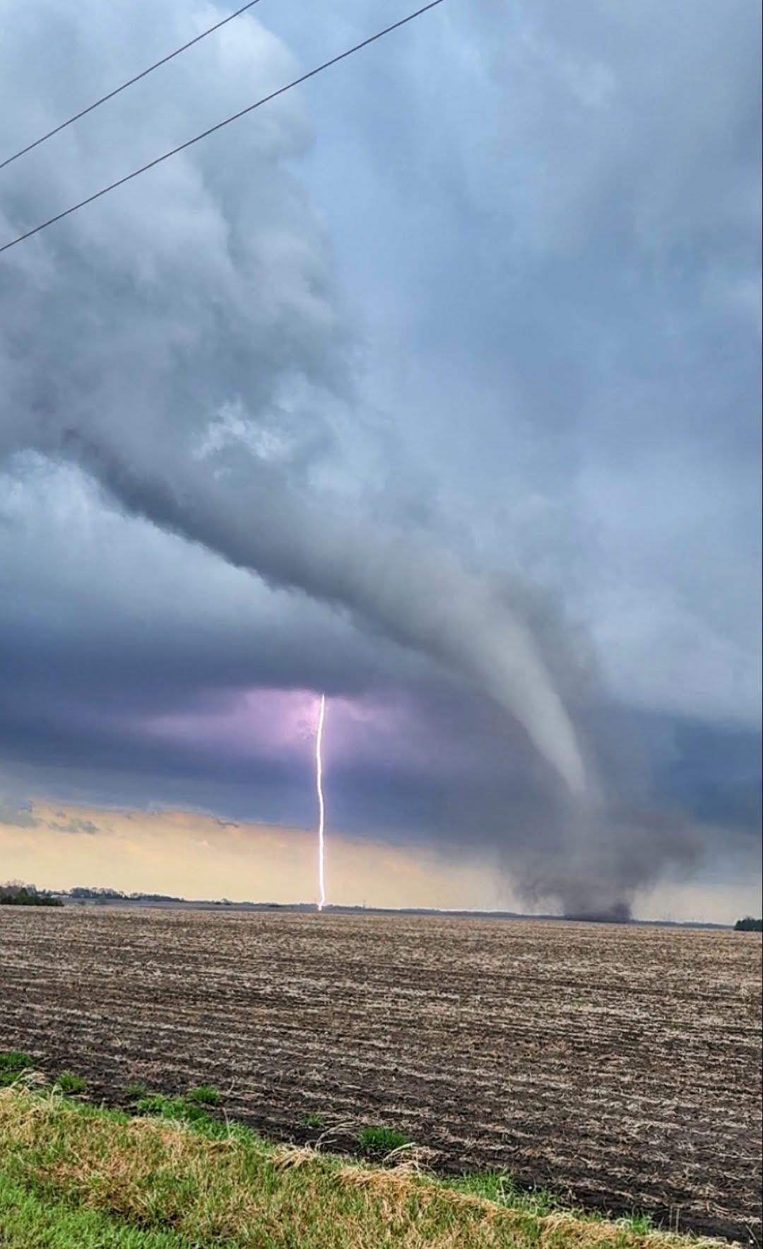 这是美国明尼苏达州东南部奥斯陆镇附近拍摄的极端天气照片，闪电与疑似龙卷风罕见同框