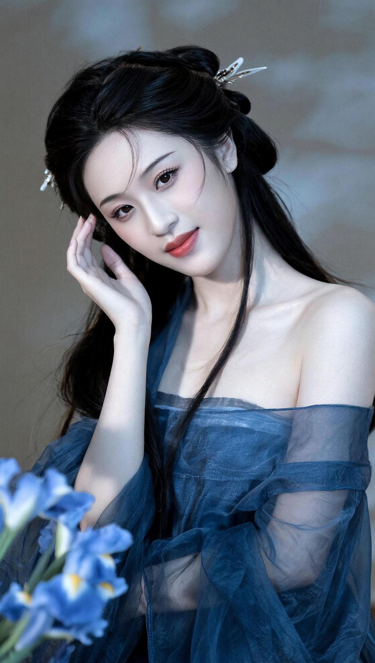 在柔和的光影中，她仿佛从古代画卷中走出，带着一丝神秘与优雅。轻纱如云，随风而动，