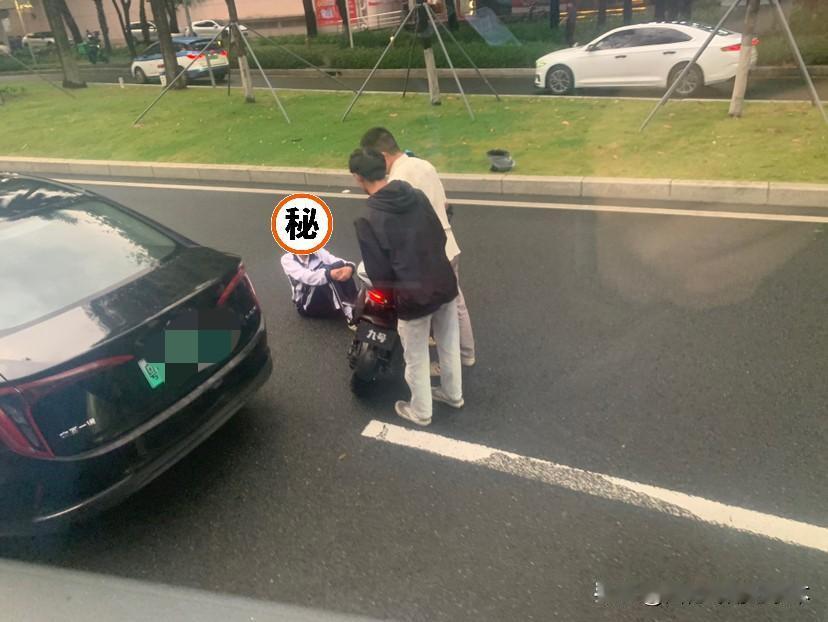 鬼火少年骑电动车走在深圳滨河大道被网约车碰了，还好有戴头盔，看起来没大碍，不知道