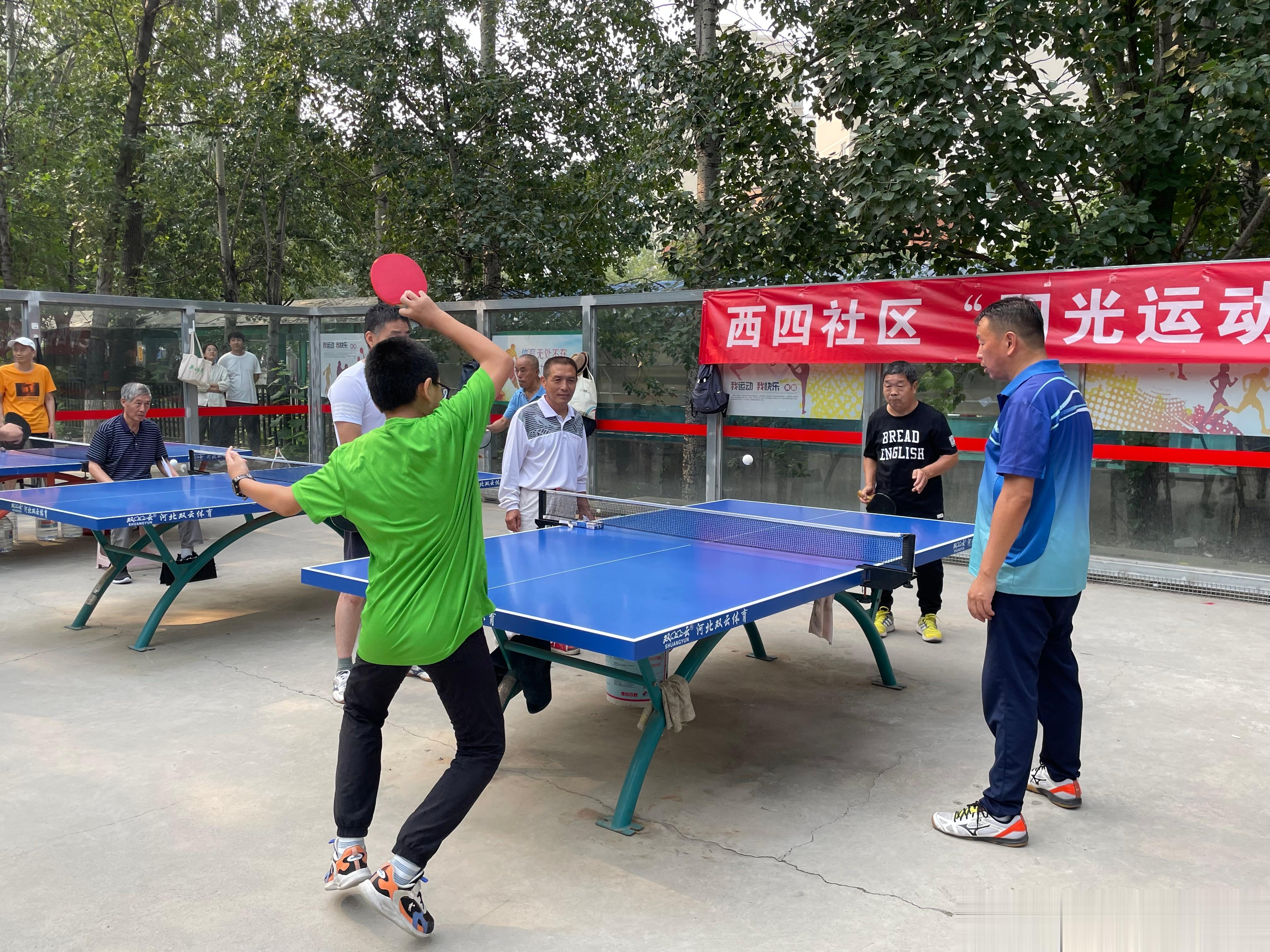 我每天都去这个露天球场打球，今天是全体球友自愿报名参加的乒乓球比赛，我不参加比赛