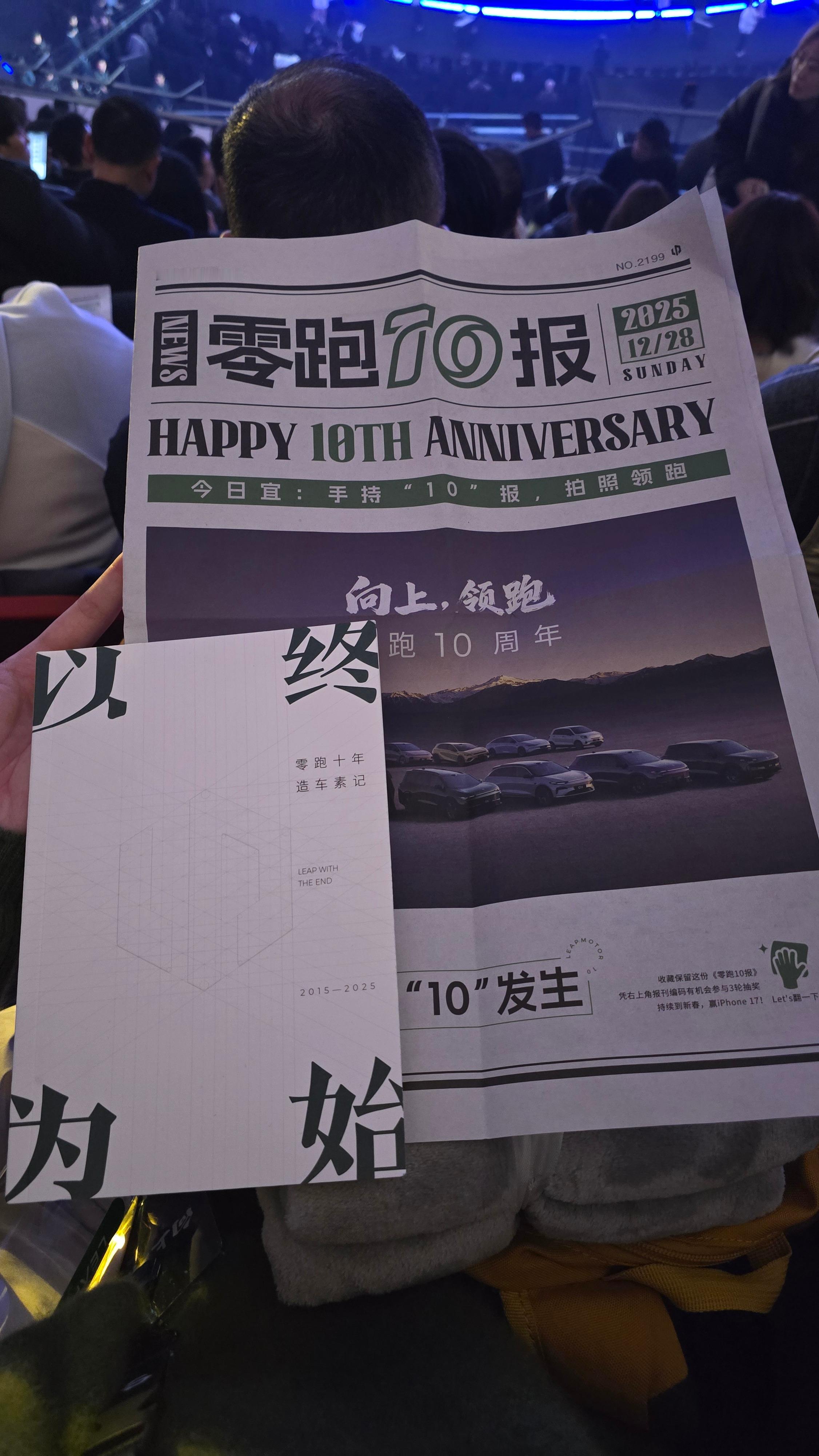 零跑 10 周年发布会，一张记录了零跑技术成果的报纸，和一本写了零跑 10 年造