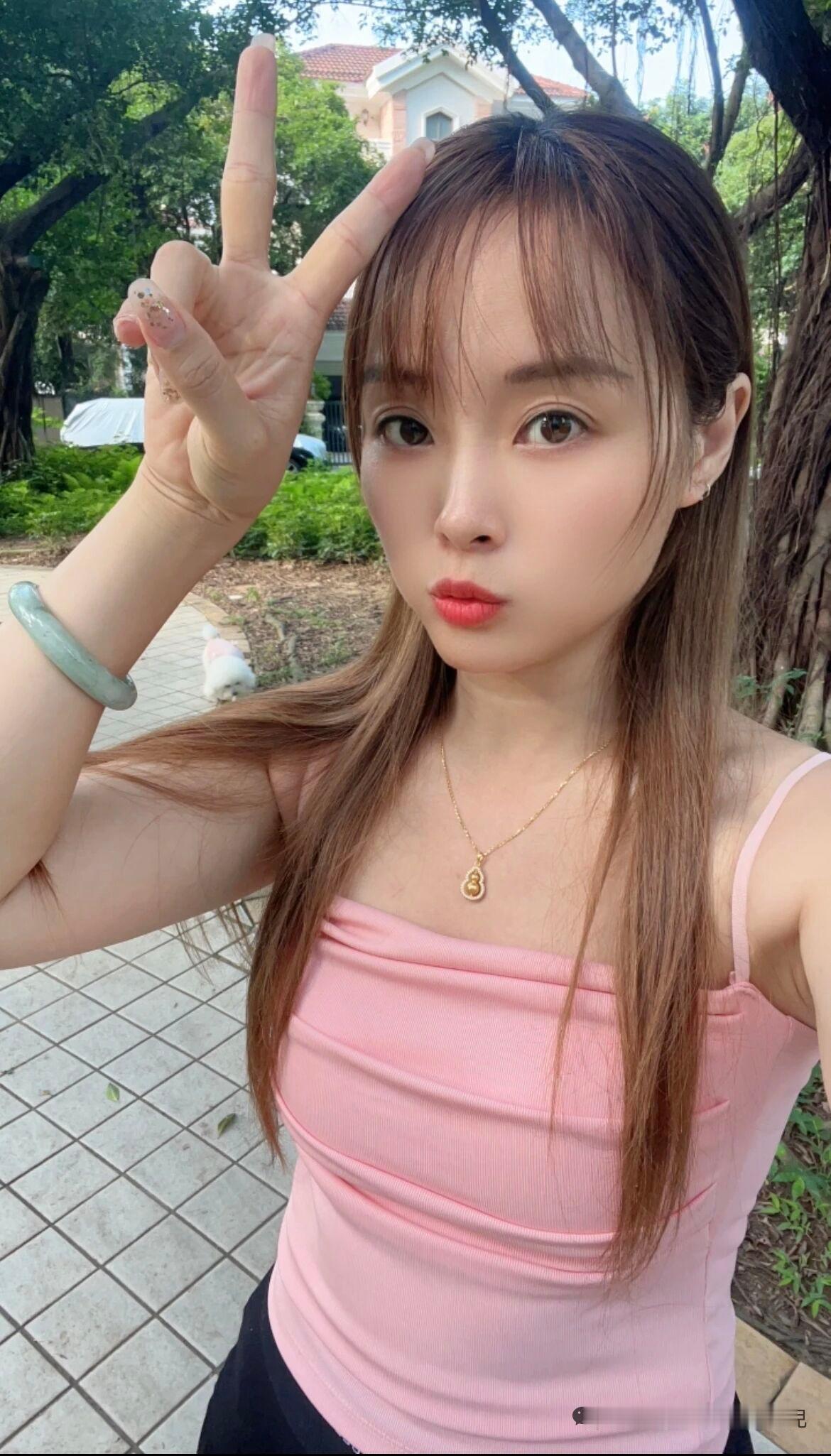 在公园里，一个女孩比着V字手势。