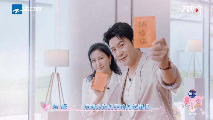 鲍蕾陆毅拿女儿手绘结婚证走红毯天声一对在《天声一对》的红毯上，陆毅鲍蕾手里的结婚