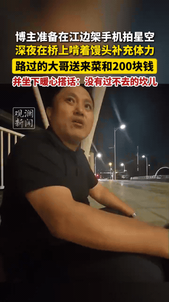 深夜的大桥上，博主准备架起手机拍摄江边星空，独自坐在路边啃着馒头垫肚子。
 
这