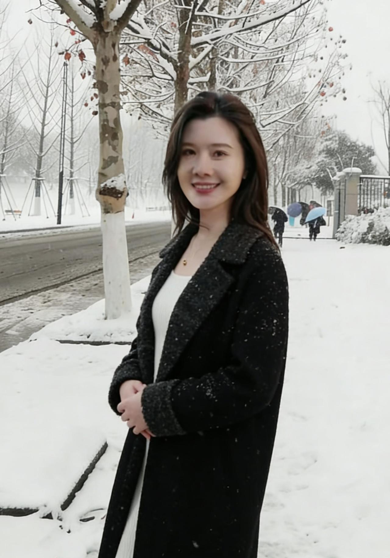 黑裘随风影婷婷，笑靥轻扬照眼明。
莫道寒冬风物寂，一枝擎雪胜花红。
