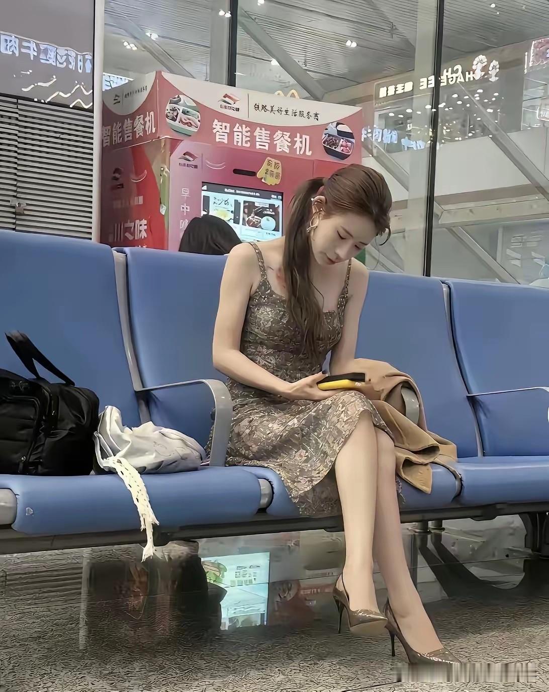 车站休息室的女人身材好苗条哦，细长腿白胳膊，配上一条碎花布裙子，给人一种从未有过
