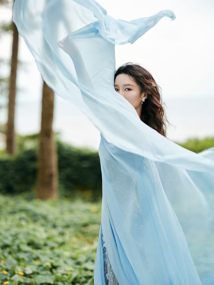李沁蓝裙卷发 李沁蓝裙卷发造型出图，微风吹拂好有氛围感期待住了！[哇] ​ ​​