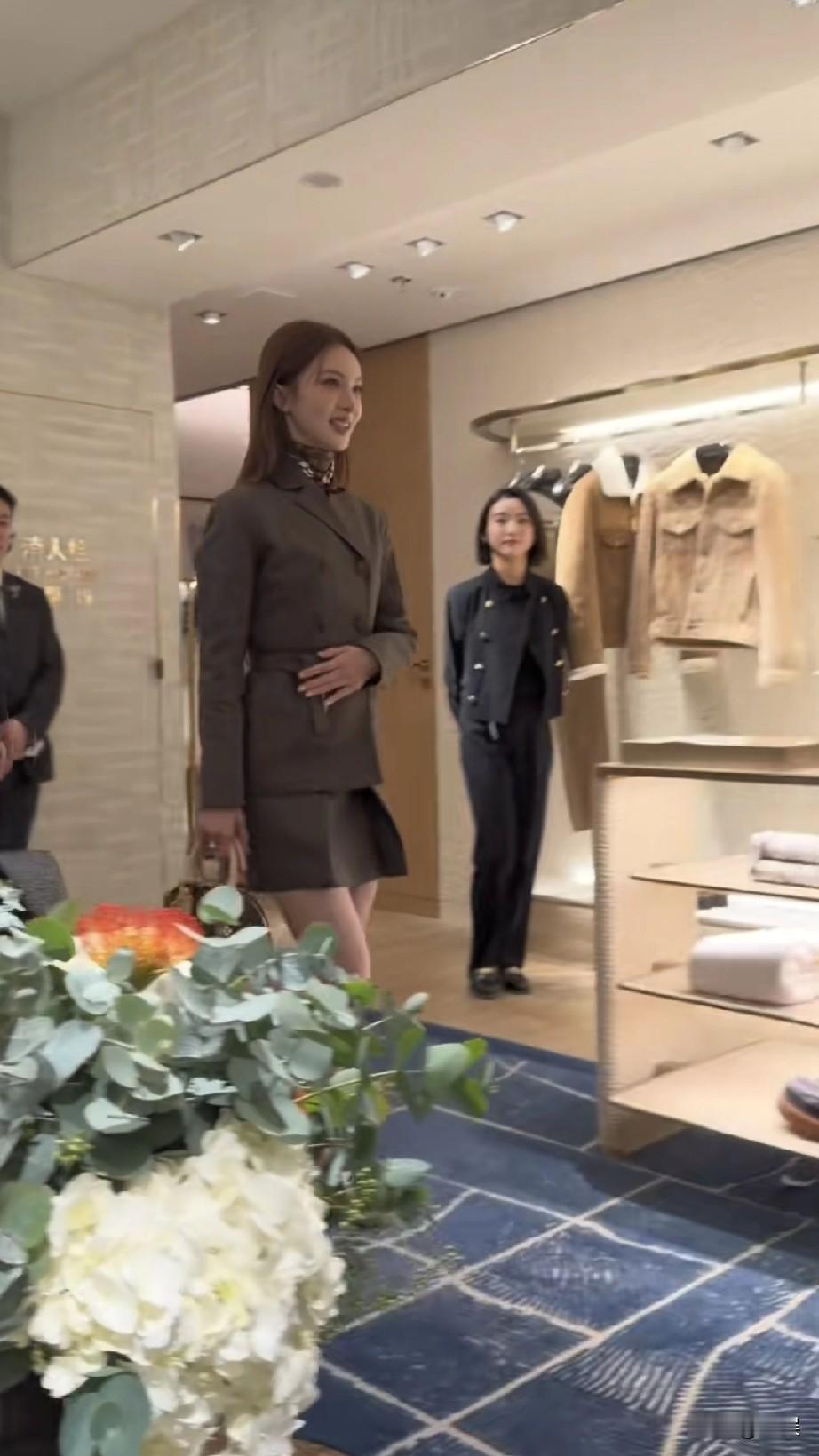 金晨她身着精致的西装套装，搭配单肩包，挥手间