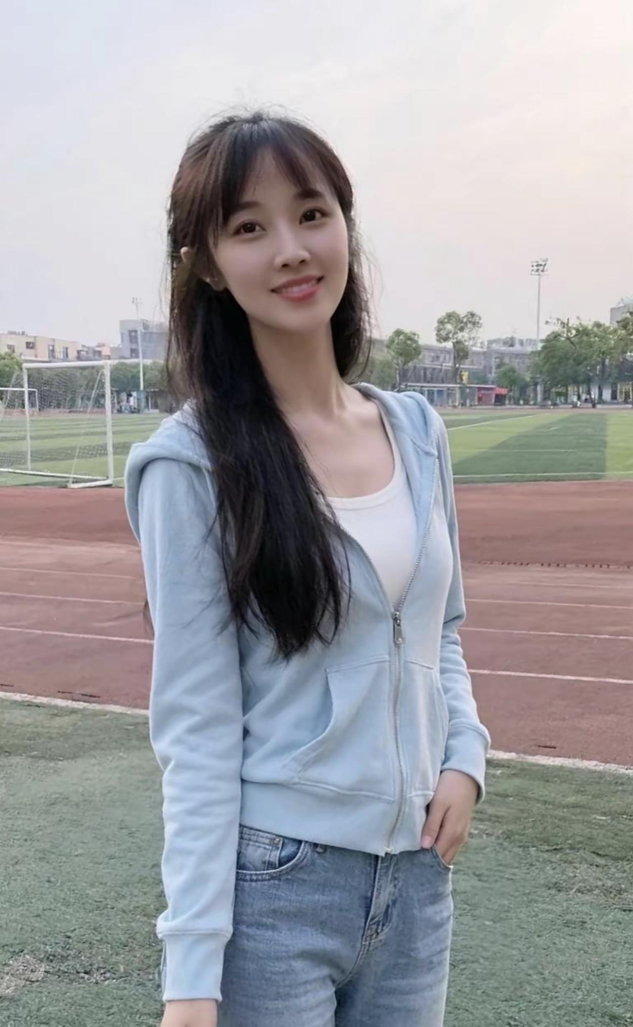 一个女孩在操场边微笑。 女生笑容 漫步微笑 海边微笑少女 户外微笑 街头微笑女孩