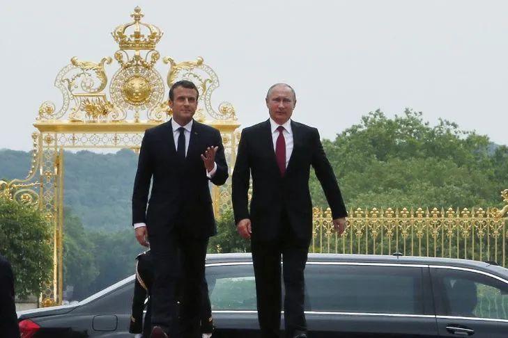 马克龙与普金走在一起，两人气场足，背后大门更是气派，金碧辉煌的样子太吸睛。