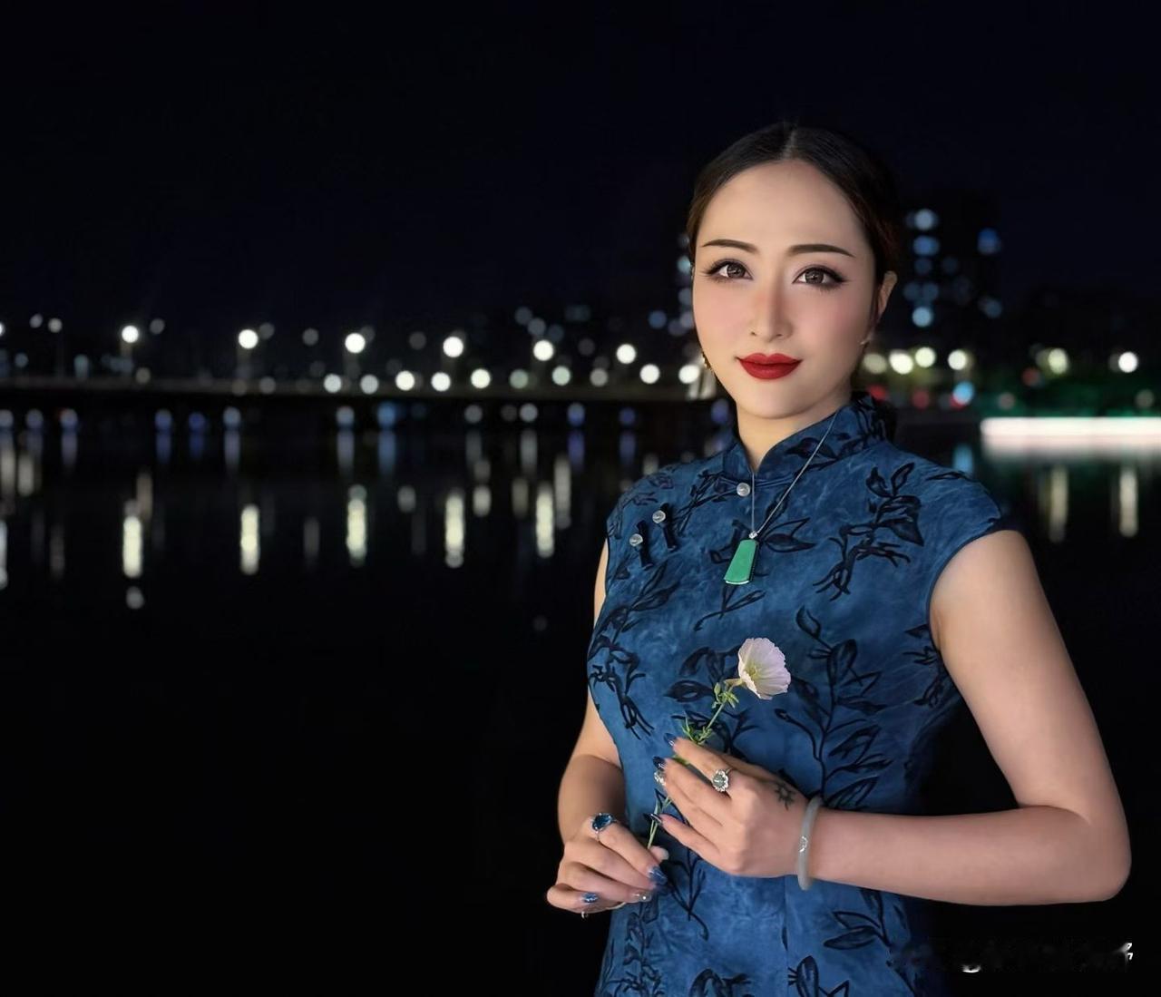 夜晚的湖畔，优雅的旗袍女子，手持一朵花，静谧而美丽。重庆“渝城灯靓”让每束光照进