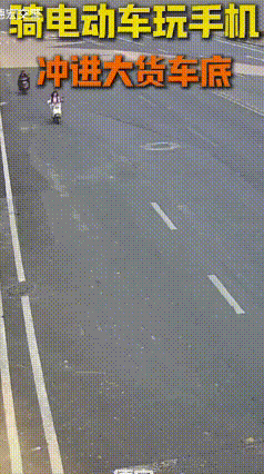 一女子骑电动车时，全程低头刷手机，眼睛几乎没离开屏幕。
路过路口时，一辆大货车正