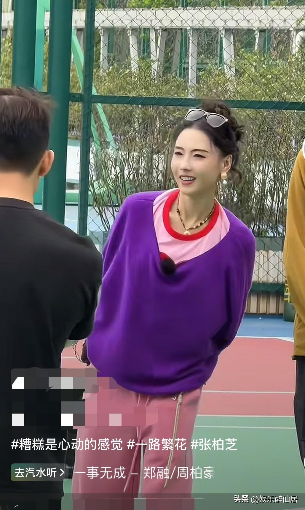 孩子都这么大了还这么有活力，
只有张柏芝能做到吧，手里拿着相机，一身粉色和紫色的