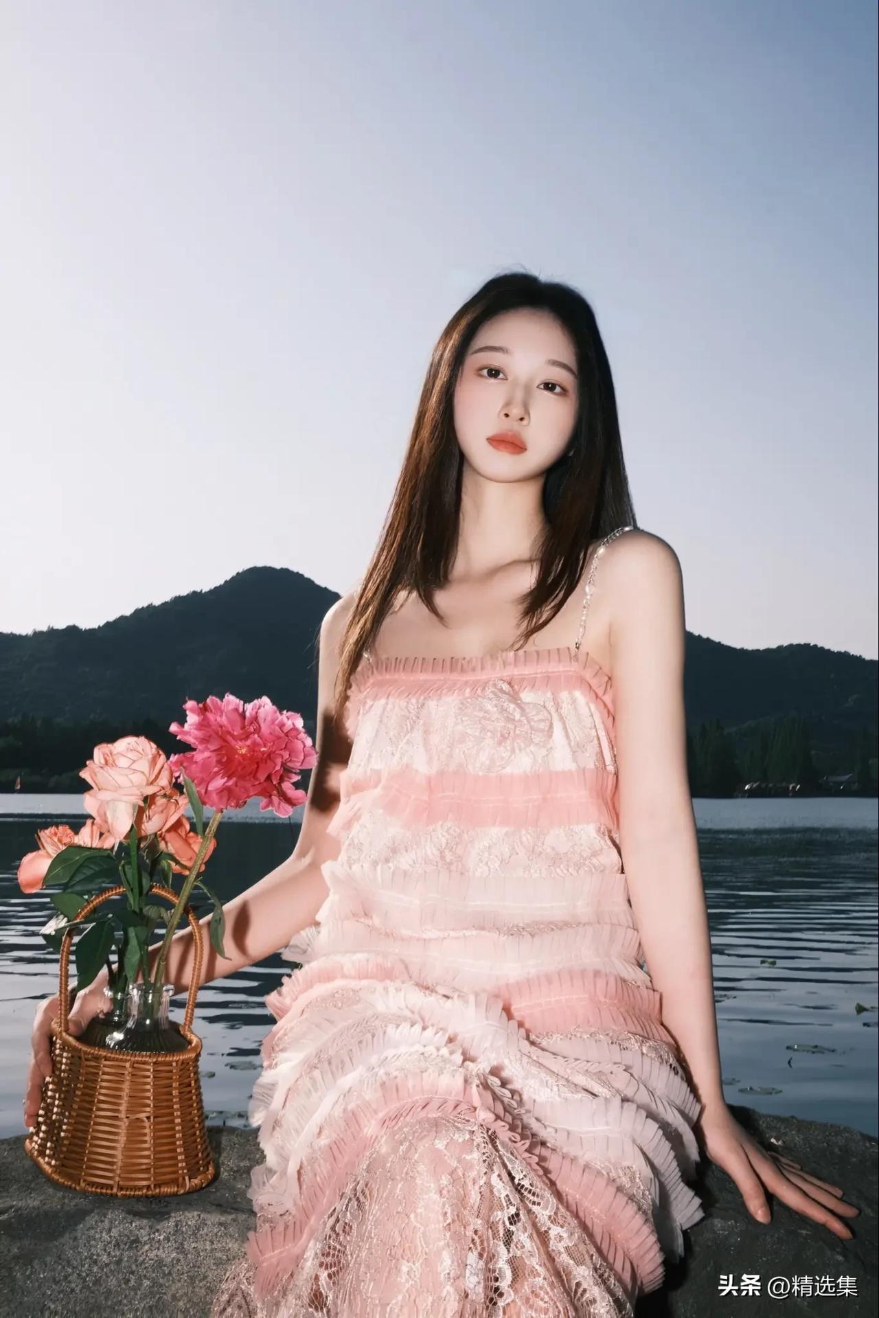 穿粉色裙子的女生在湖边拍照。