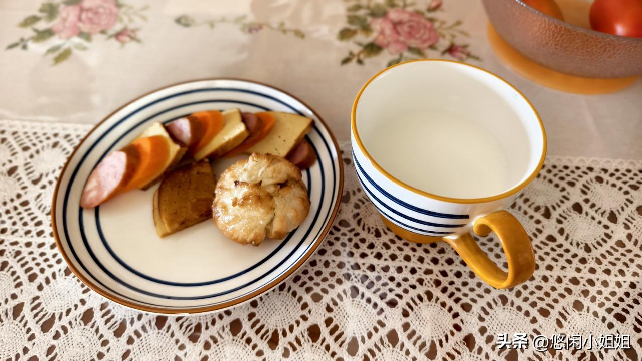几片豆腐、几片红肠和几片蒸胡萝卜，一个烤馒头，里面是红糖芝麻馅。一杯完达山鲜奶。