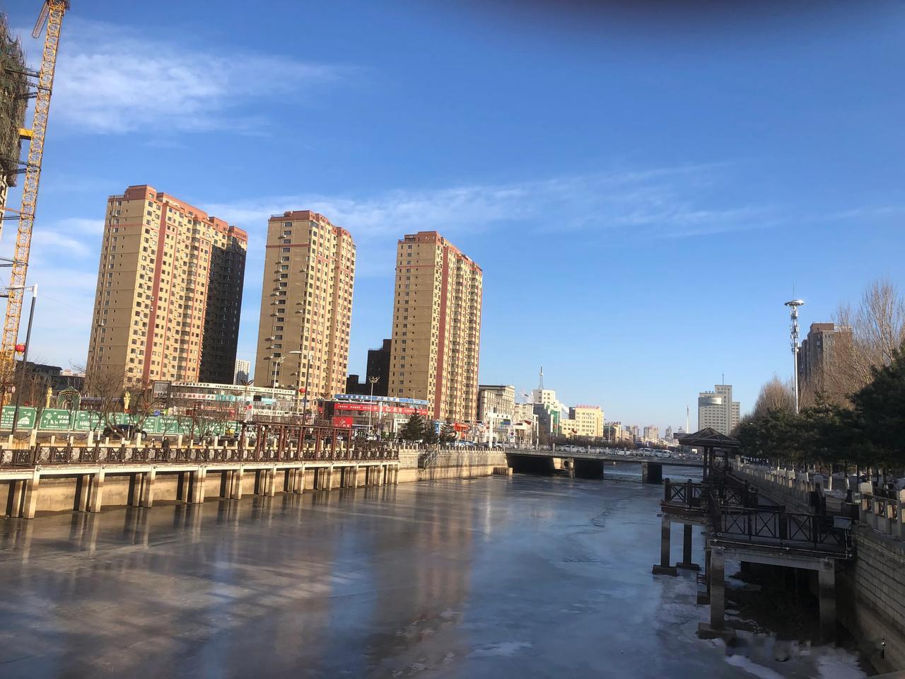 天高云淡，隔河看对岸。高楼耸入云天里，遮挡阳光一片。
