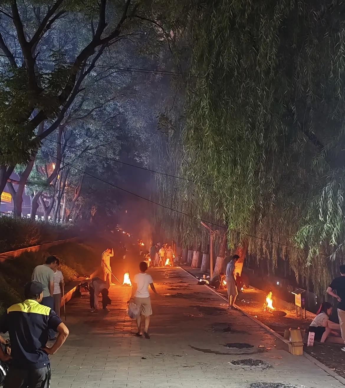 今天中元节，许多城市街头巷尾都燃起了一堆堆火光，三五成群的人们在十字路口画圈焚纸